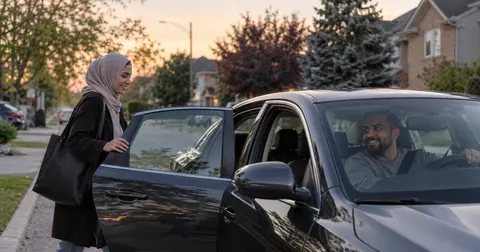 Rideshare driver picking up a passenger at dusk
