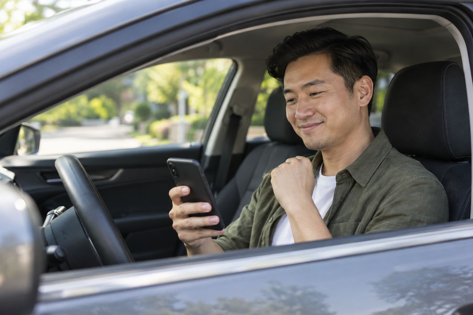 Driver in his parked car looking relieved after finding coverage